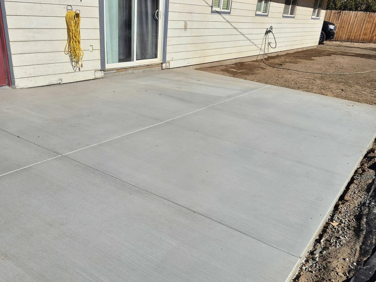 Finished concrete slab along the back of a white house, building pads