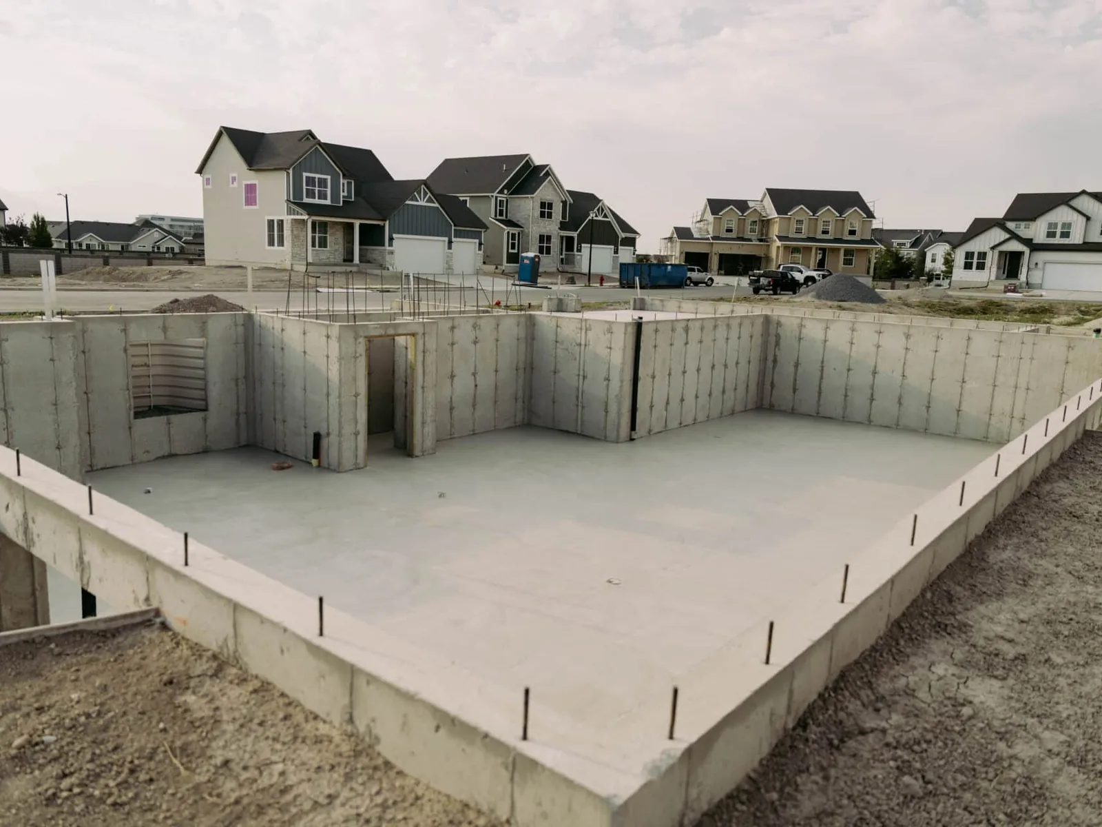 Excavated lot around a new poured basement foundation, site preparation